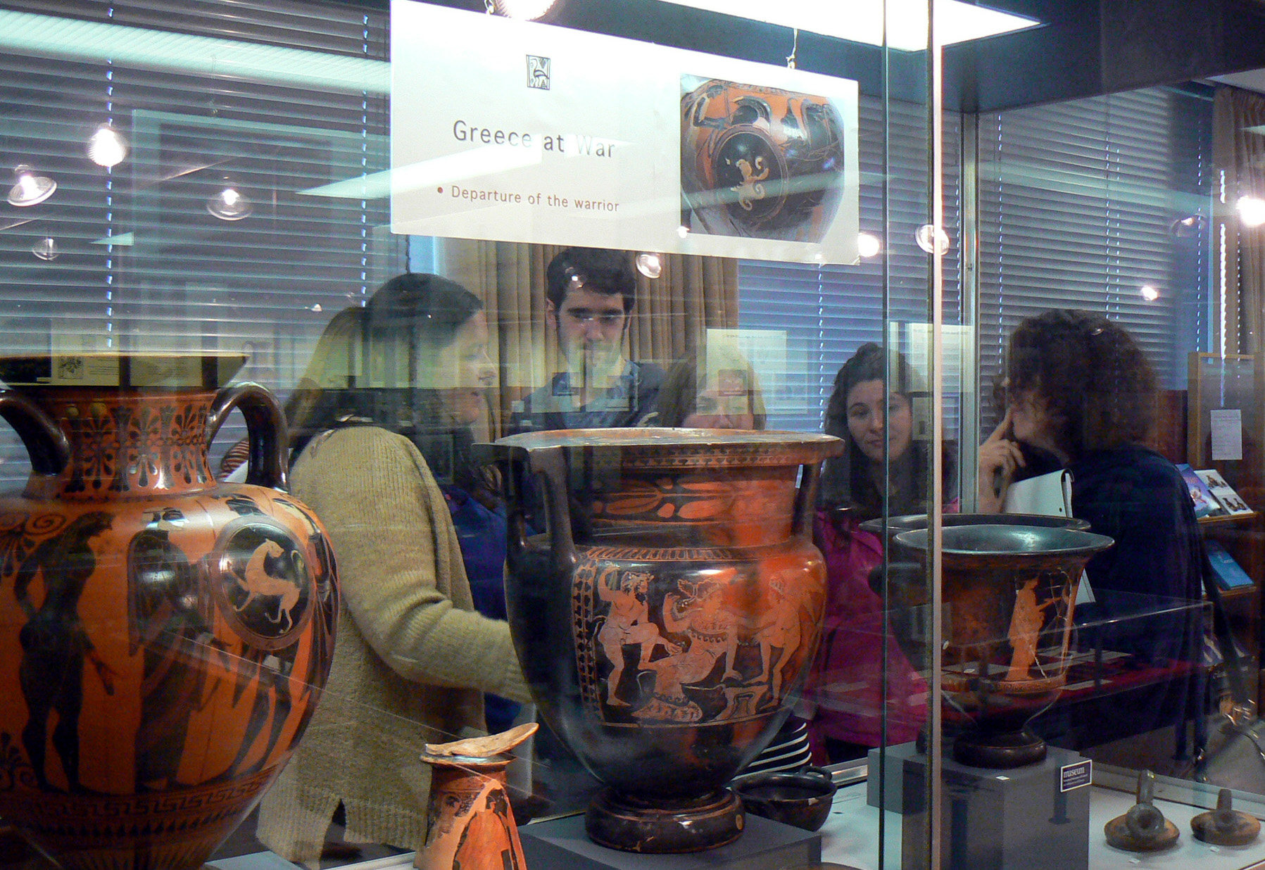 MA students examine vases in a case
