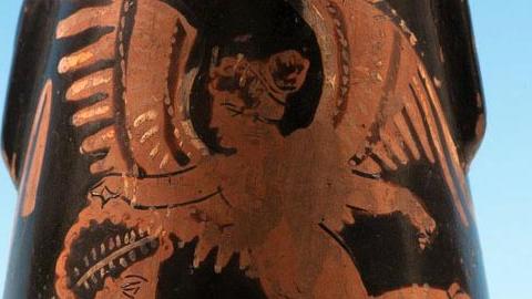 Eros crowns a young man, red figure. Aphrodite sits on the right.